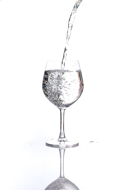 Photo close-up of water pouring in wineglass against white background