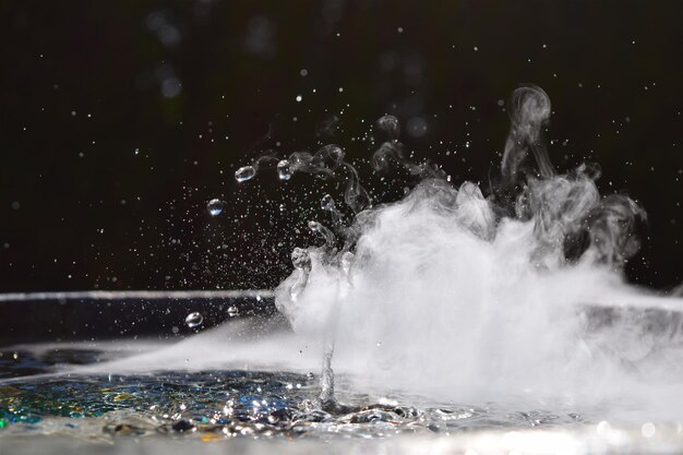 Photo close-up of water splashing against black background