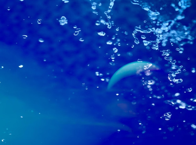Foto close-up di spruzzi d'acqua su uno sfondo blu
