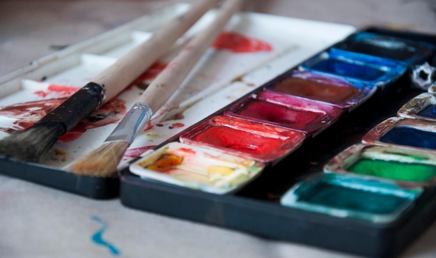 Close-up of watercolor paints with paintbrushes