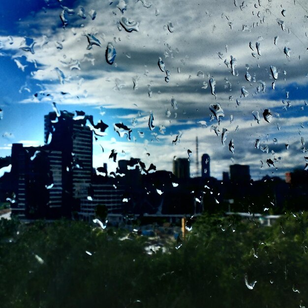 Foto close-up di gocce d'acqua sul vetro contro gli edifici