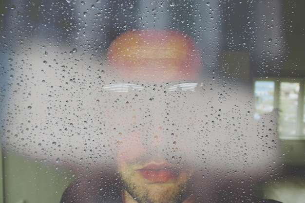 Foto close-up di gocce d'acqua su vetro un uomo