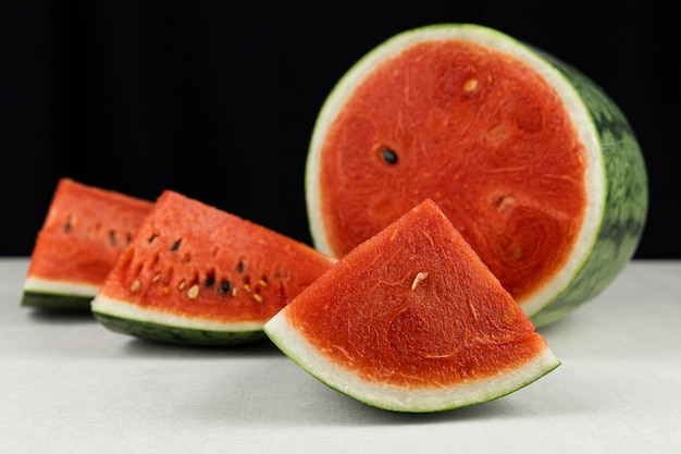 Close-up watermelon on concrete table and black color wall.