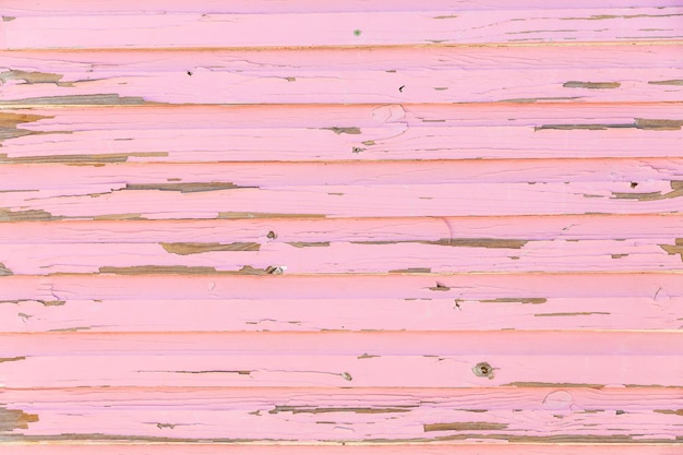 Foto close up di verniciatura rosa intemperata su tavole di legno di una baracca sulla spiaggia con spazio per le copie.