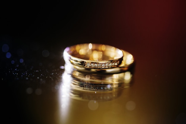 Close-up of wedding golden rings on dark