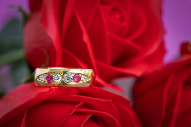 Close up wedding ring and red rose