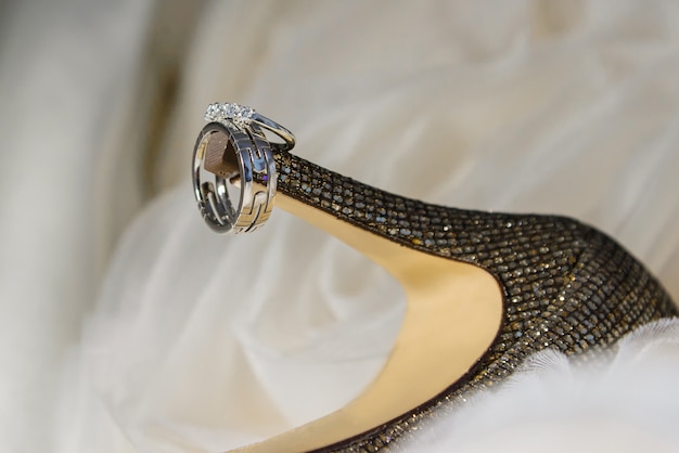 Close up of wedding rings on bride's shoes