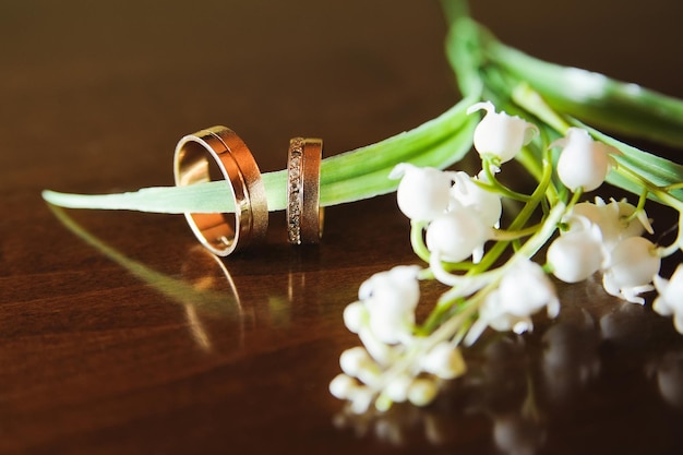 テーブルの花の上に置かれた結婚指輪のクローズアップ