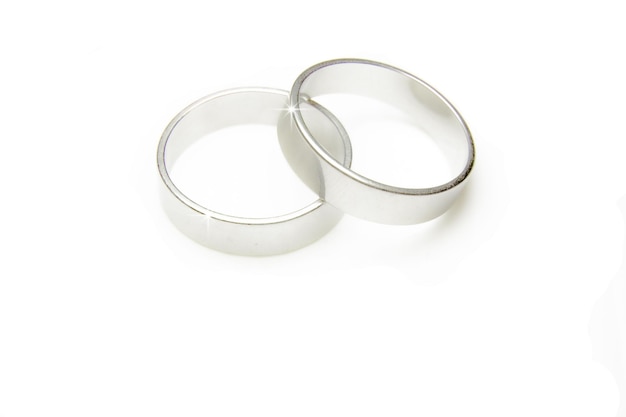 Foto close-up di anelli nuziali su sfondo bianco