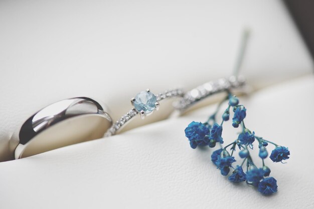 Photo close-up of wedding rings with artificial flower in box