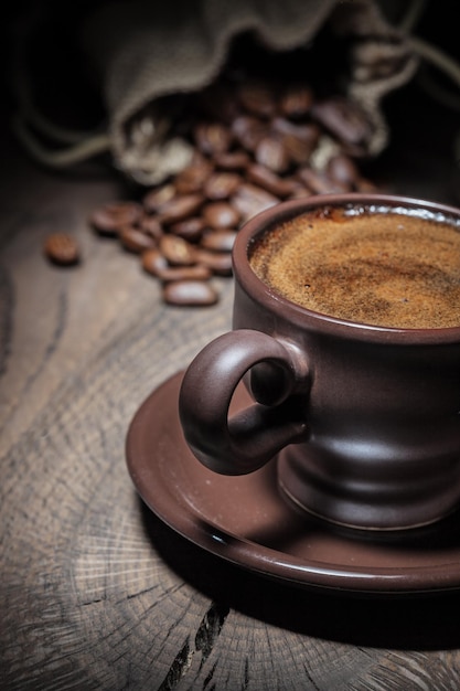 Close-up weergave espresso in klei koffiekopje en zak met bonen