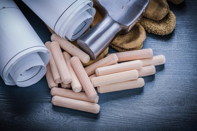 Close-up weergave opgerolde blauwdrukken hamerhandschoenen houten deuvels