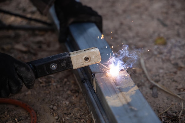 Photo close-up of welder working with welding tool