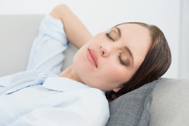 Close up of a well dressed beautiful woman sleeping on sofa