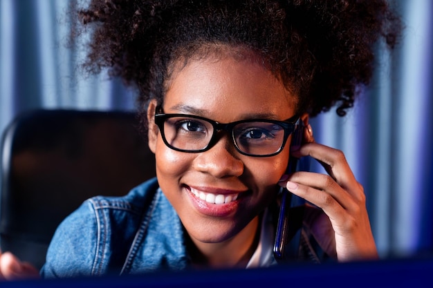 Close-up werkende Afrikaanse vrouw bellen en bespreken met vriend zoeken marketing data-analyse of nieuwe projectbaan studeren op laptop Concept van persoon in selectieve focus fotoprofiel Smaakmaker