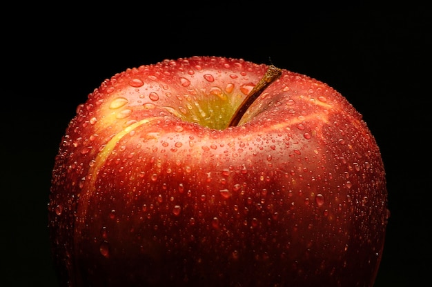 Photo close-up of wet apple against black background