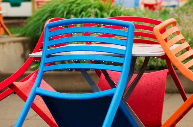 Foto close-up di sedie colorate bagnate disposte all'aperto