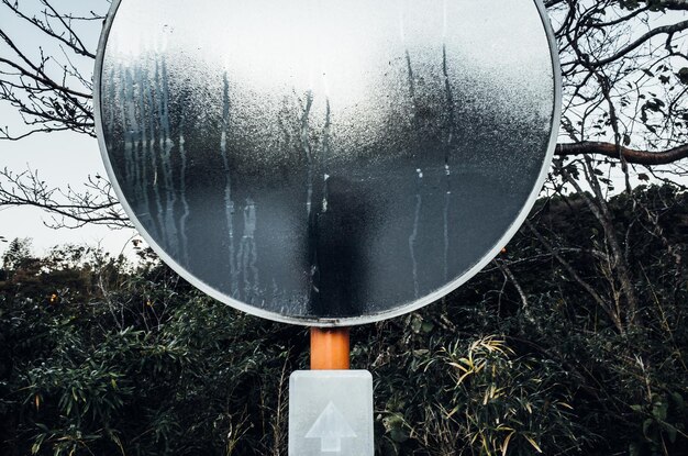 Foto close-up di una persona riflessa in uno specchio convesso bagnato