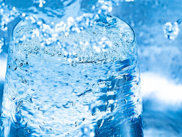 Photo close-up of wet glass against blue water