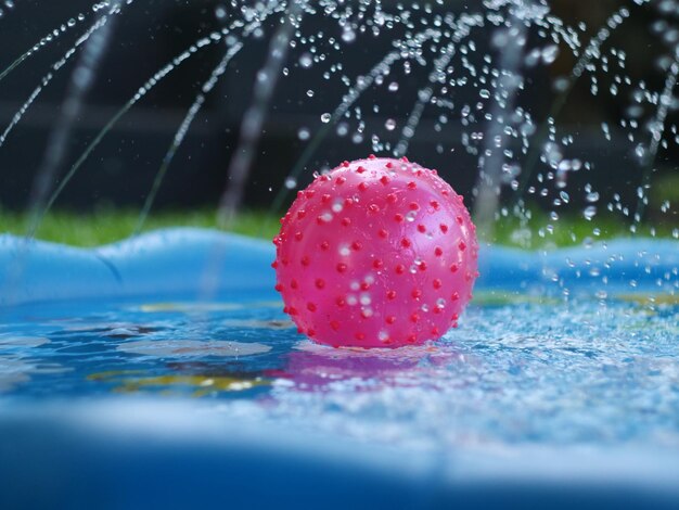 Foto close-up di una palla rossa bagnata in piscina