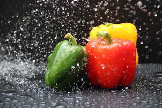 Foto close-up di bacche rosse bagnate sull'acqua contro uno sfondo grigio