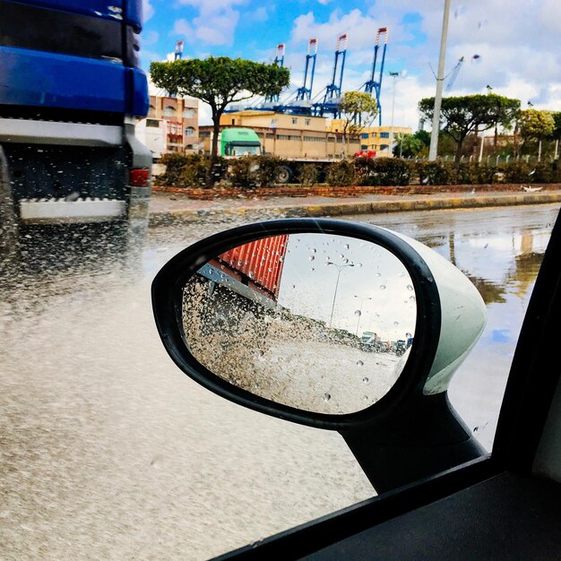 Close-up of wet side-view mirror of car