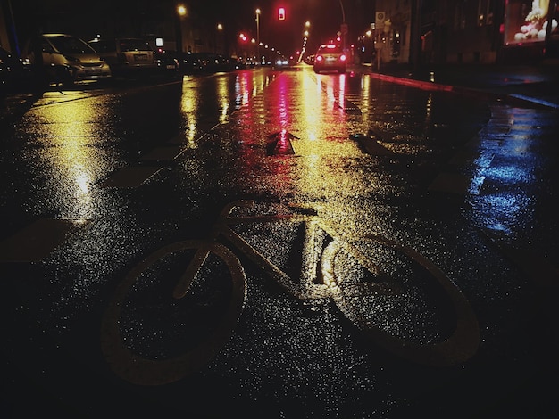 Foto close-up di una strada bagnata in città di notte
