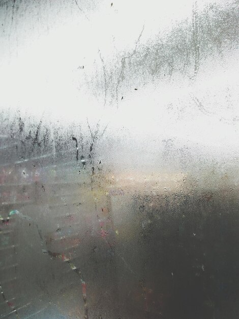 Photo close-up of wet window against sky