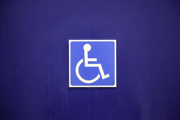 Photo close-up of wheelchair access sign on wall