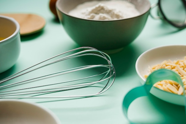 Close-up whisk with baking supplies on the table