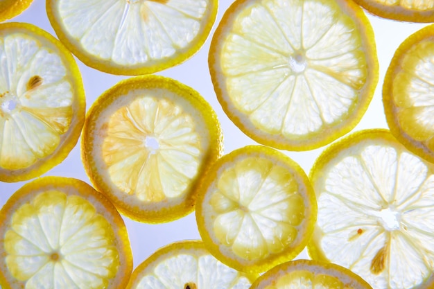 Крупным планом белый фон с прозрачными ломтиками лимона и видимыми семенами