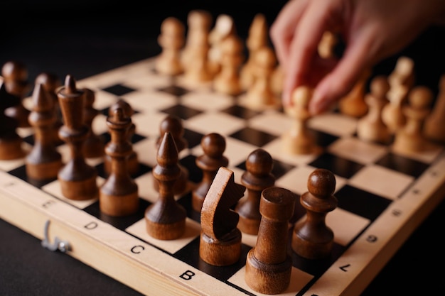 Close up of white and black chess pieces on board Selective focus on first move of white pawn on chessboard Concept of intelligent logical and strategic game