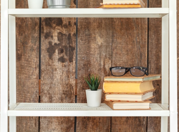 Close up of white bookshelf against grunge wooden wall