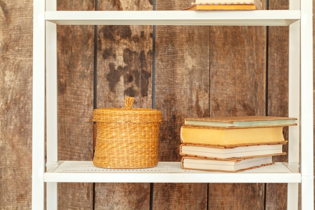 Close up of white bookshelf against grunge wooden wall