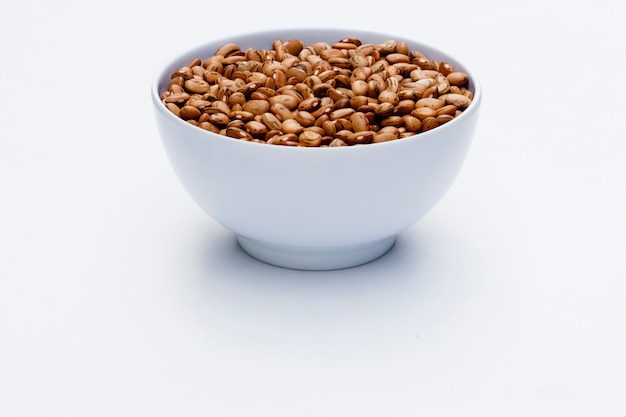 Close-up in white bowl with mulatto beans isolated