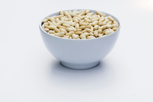 Close-up in white bowl with white beans isolated