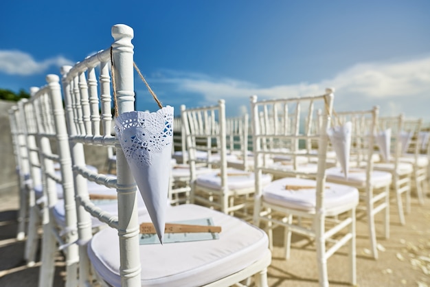 Close-up le sedie bianche di chiavari per location per matrimoni in spiaggia