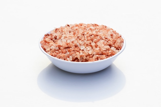 Close-up in white container filled with granulated pink salt