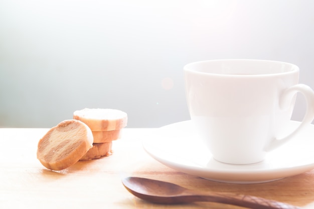 Close up of white cup and cookies on wooden board, Morning and lifestyle concept