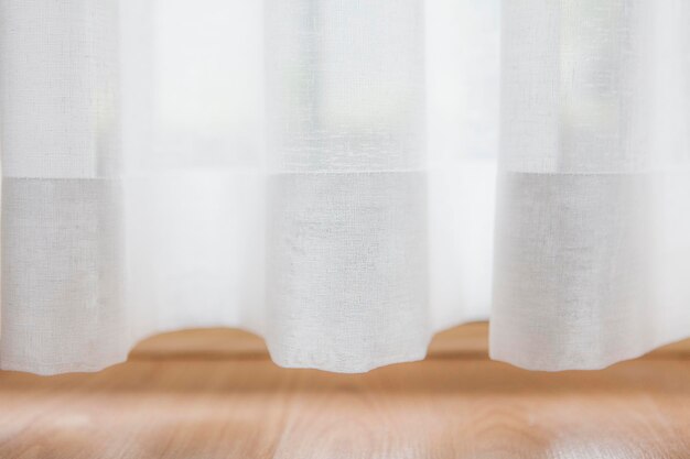 Photo close-up of white curtain on table at home