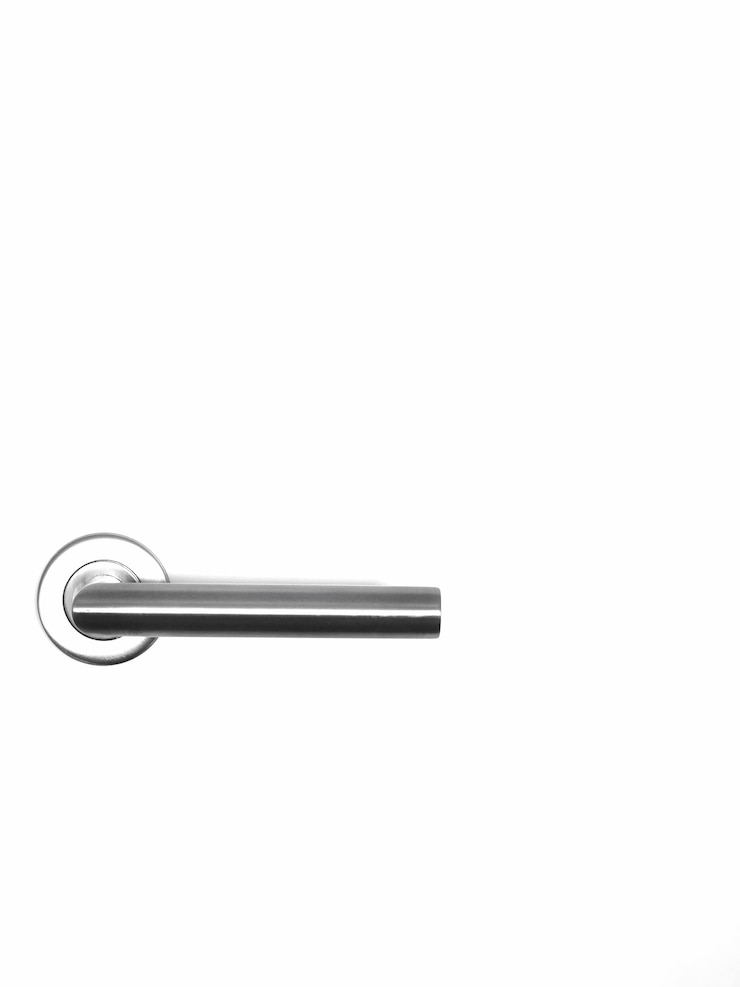 Photo close up of a white door with metallic handle