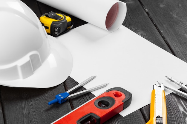 Close up white hardhat and variety of repair tools with copy space in the middle