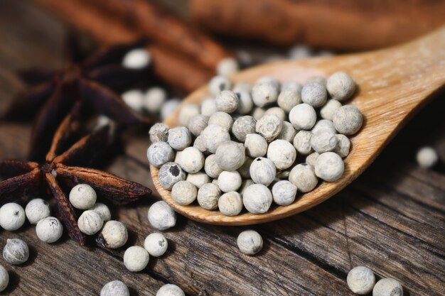 Close-up of white peppercorns on wooden spoon