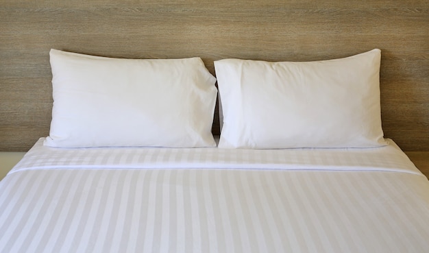 Close up white pillows on bed in hotel.