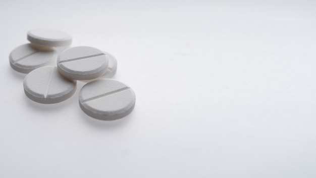 Close up of white pills on white background, medicine and health care concept