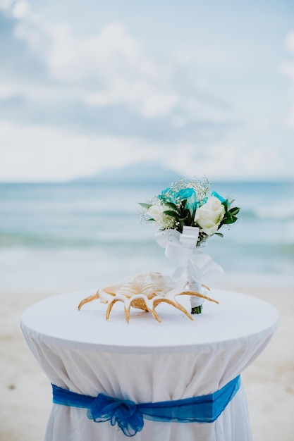 Foto close-up di una rosa bianca sulla spiaggia