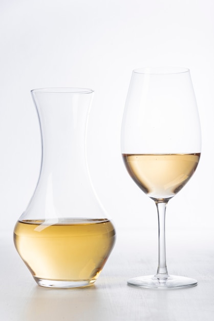 Foto primo piano bicchiere di vino bianco e decanter