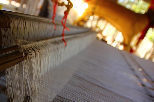 Close up white yarns on wood loom weaving ready to produce.