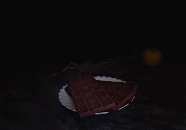 Photo close-up of wicker basket on bed against black background