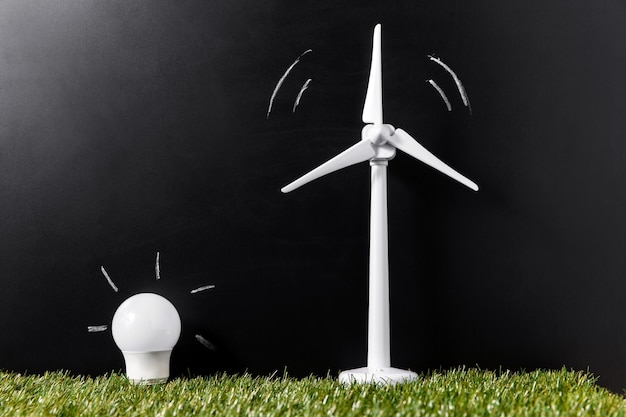 close up of wind turbine and lightbulb on grass